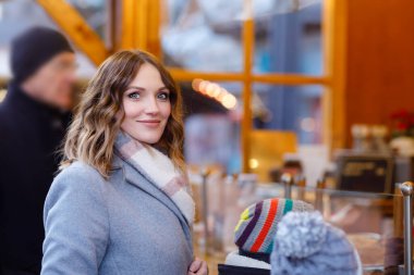 Güzel genç bir kadın, şiddetli kar yağışında geleneksel Noel pazarında eğleniyor. Lebkuchen adında geleneksel zencefilli ekmek alan mutlu bir kız..