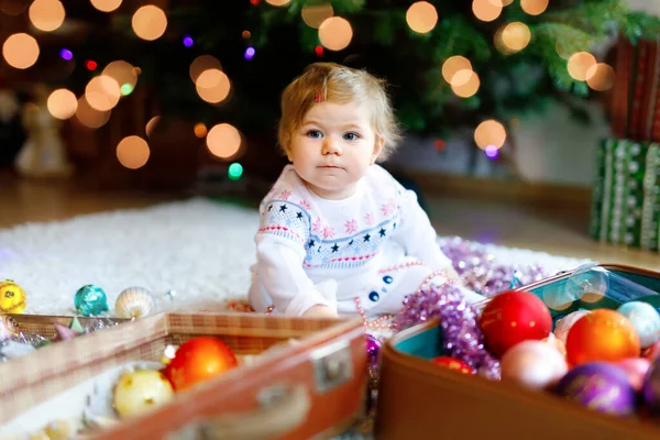 可爱的小女孩用可爱的手捧着五彩缤纷的灯饰.穿着节日服装和家人一起装饰圣诞树的小孩。传统假日的第一个庆祝活动是威赫纳腾节 — 图库照片