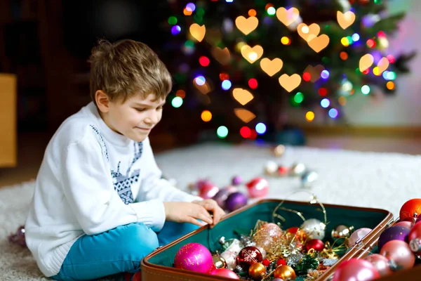 Beautiful kid boy and colorful vintage xmas toys and balls. Child decorating Christmas tree — Stock Photo, Image
