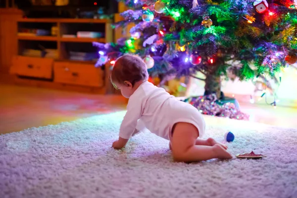 Adorável menina segurando luzes coloridas guirlanda em mãos bonitos. Criança em roupas festivas decorando a árvore de Natal com a família. Primeira celebração do feriado tradicional chamado Weihnachten — Fotografia de Stock