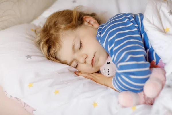 Linda niña pequeña que duerme en la cama con lama de juguete de peluche suave favorito. Adorable bebé niño soñando, sueño saludable de los niños por el día. — Foto de Stock