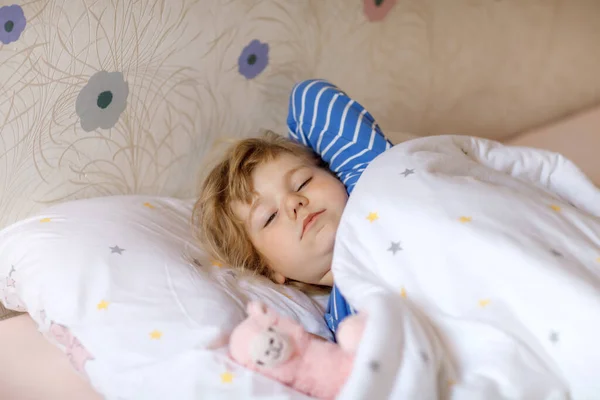 Roztomilé malé batole dívka probudit a spát v posteli s oblíbenou měkkou plyšovou hračkou lama. Rozrušený smutné dítě snění, zdravý spánek dětí ve dne. — Stock fotografie