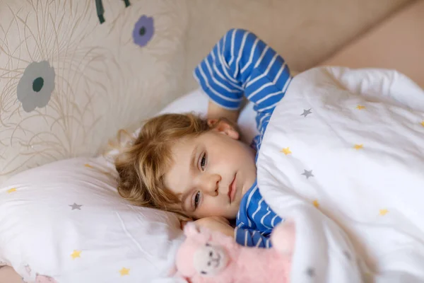 Cute little toddler girl wake up and sleep in bed with favourite soft plush toy lama. Upset sad baby child dreaming, healthy sleep of children by day. — Stock Photo, Image