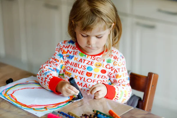 Lilla småbarn flicka måla regnbågar med krita färger under pandemisk coronavirus karantän sjukdom. Barn måla regnbågar runt om i världen med orden Låt oss alla vara bra. Lyckligt barn — Stockfoto