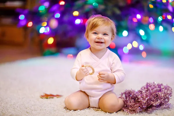 Adorável menina segurando luzes coloridas guirlanda em mãos bonitos. Criança em roupas festivas decorando a árvore de Natal com a família. Primeira celebração do feriado tradicional chamado Weihnachten — Fotografia de Stock