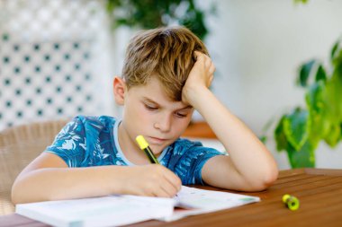 Çalışkan, mutlu okul çocuğu Corona salgınından dolayı karantina zamanında ödev yapıyor. Kalemle yazan sağlıklı bir çocuk, evde kalıyor. Evde eğitim kavramı