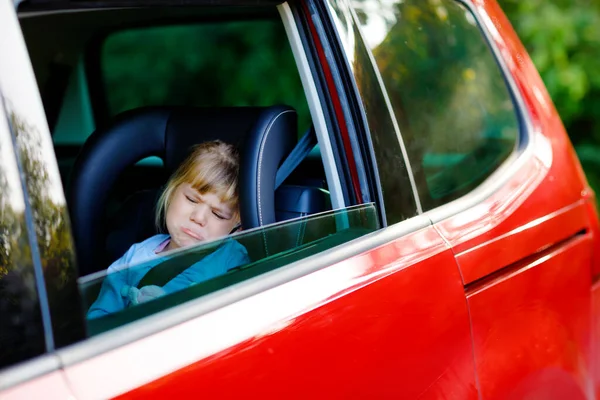 Λυπημένος αναστατωμένος μικρό κορίτσι κάθεται στο αυτοκίνητο σε μποτιλιάρισμα κατά τη διάρκεια των καλοκαιρινών διακοπών με τους γονείς του. Κουρασμένο, εξαντλημένο παιδί που δεν χαίρεται για το μακρύ ταξίδι. Κλαίει μωρό μου. — Φωτογραφία Αρχείου