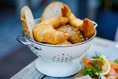 Kahvaltı için açık bir kafede kahvaltıda farklı türde ekmek ve kruvasan yakın plan.