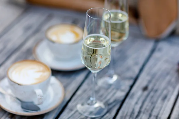 Primer plano de dos copas de champán y dos tazas de capuchino o café para el desayuno romántico en la cafetería al aire libre o restaurante del hotel —  Fotos de Stock