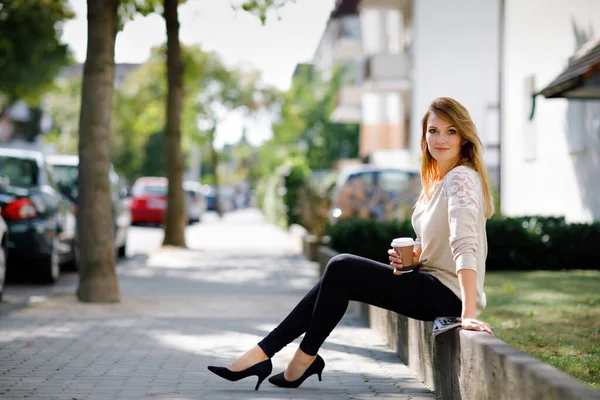 Schöne Frau, die mit einer Tasse Kaffee to go zur Arbeit geht. Junge Dame genießt Morgenspaziergang, glückliche, lächelnde Person mit langen Haaren. — Stockfoto