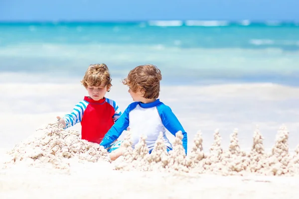 Playa del Carmen, Meksika 'da tropik plajlarda kumdan kale inşa eden iki çocuk. — Stok fotoğraf