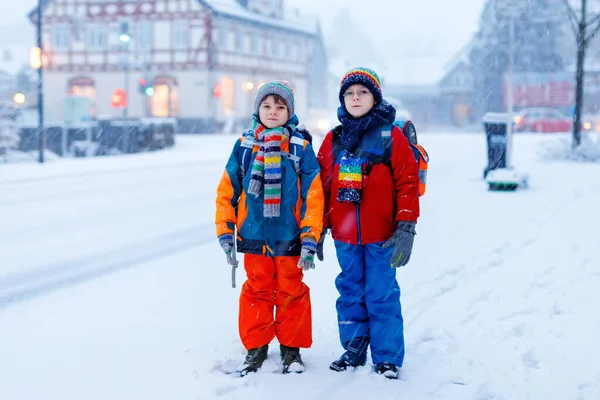 Dos niños pequeños de la clase primaria caminando a la escuela durante las nevadas — Foto de Stock