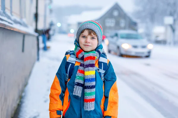 Niño feliz divirtiéndose con nieve camino a la escuela — Foto de Stock