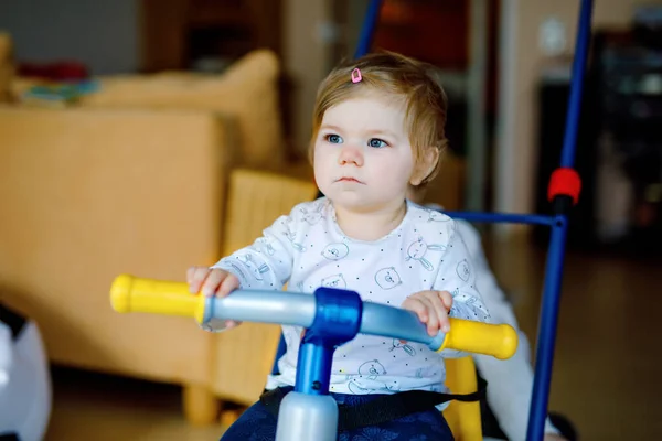 A kissrác biciklit vagy triciklit tologatott az édes kishúgával. Toddler lány és testvér együtt játszanak otthon, a házban. Testvéri kötelék és szeretet, közös és közös tevékenység és játék. — Stock Fotó
