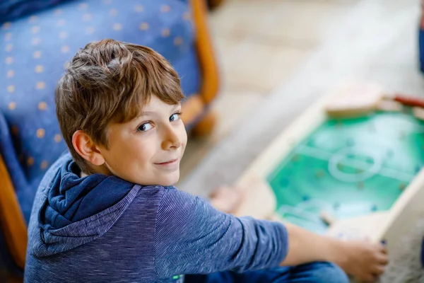 집에서 친구들과 테이블 축구하는 행복 한 소년. 집안일을 시키는 아이들이 보드게임을 즐기는 모습, 실내에서. — 스톡 사진