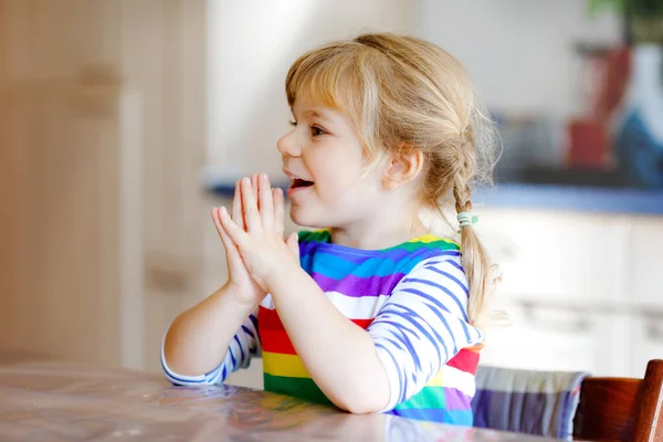 Carina la bambina che prega Dio a casa. Bambino usando le mani per pregare e ringraziare per il cibo. Tradizione cristiana. — Foto Stock