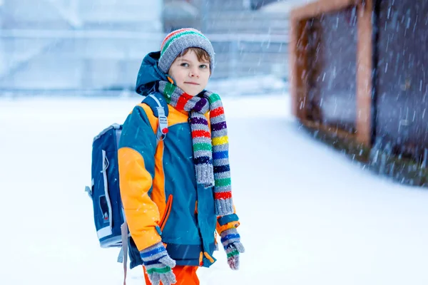 Menino feliz se divertindo com neve a caminho da escola — Fotografia de Stock