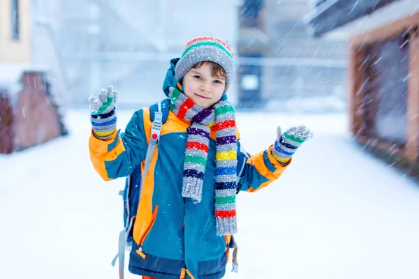 Glad pojke som har kul med snö på väg till skolan — Stockfoto