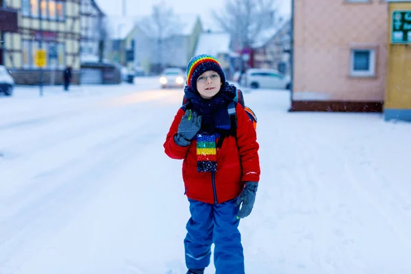 Happy kid boy with glasses having fun with snow on way to school, elementary class — Stock Photo, Image