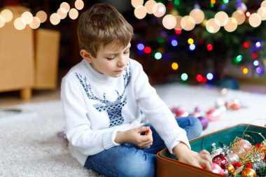 Güzel çocuk ve renkli eski yılbaşı oyuncakları ve topları. Çocuk Noel ağacı süslemesi