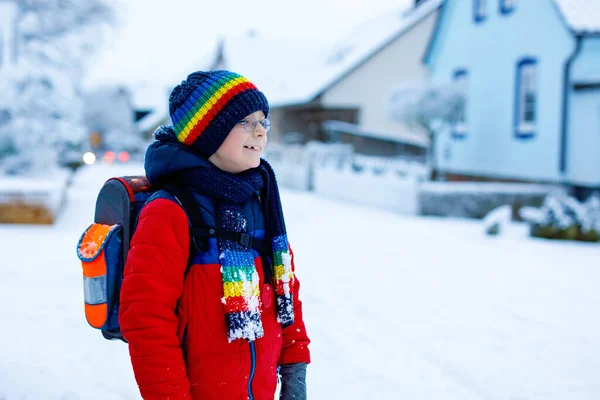 Happy kid boy with glasses having fun with snow on way to school, elementary class — Stock Photo, Image