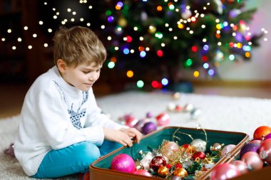 Güzel çocuk ve renkli eski yılbaşı oyuncakları ve topları. Çocuk Noel ağacı süslemesi