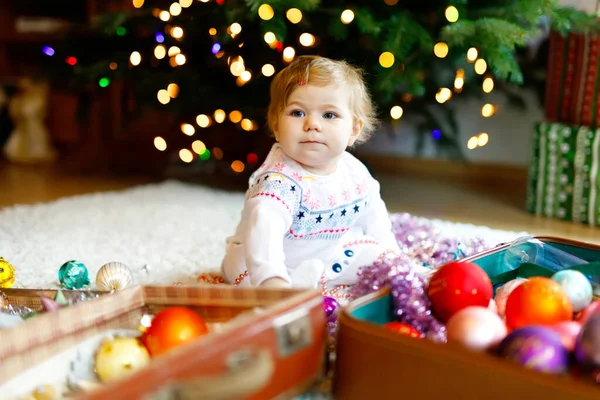 Adorabile bambina che tiene ghirlanda luci colorate in mani carine. Bambino in abiti festivi che decorano l'albero di Natale con la famiglia. Prima celebrazione della festa tradizionale chiamata Weihnachten — Foto Stock