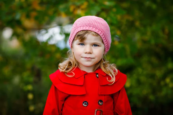 Sonbahar ormanlarında yürüyüş yapan kırmızı ceketli küçük bir kızın sonbahar portresi. Mutlu sağlıklı bebek anne babasıyla yürürken eğleniyor. Çocukla güneşli bir sonbahar günü. — Stok fotoğraf
