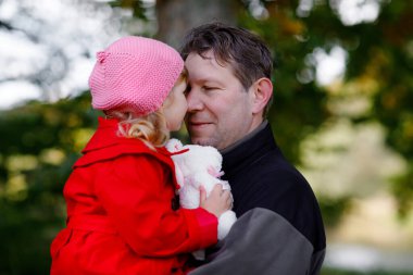 Mutlu genç baba, küçük kızıyla eğleniyor, aile portresi çiziyor. Sonbahar ormanında ya da parkta güzel bir kızı olan orta yaşlı bir adam. Baba ve küçük çocuk dışarıda, kucaklaşıyorlar. Aşk, bağlanma