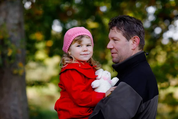 Szczęśliwy młody ojciec o zabawy cute maluch córka, rodzinny portret razem. Mężczyzna w średnim wieku z piękną dziewczynką w jesiennym lesie lub parku. Tata z małym dzieckiem na zewnątrz, przytulający się. Miłość, więź — Zdjęcie stockowe