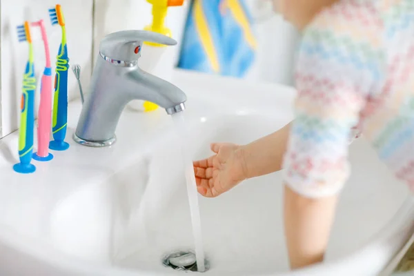 Nahaufnahme eines kleinen Mädchens, das sich im Badezimmer die Hände mit Seife und Wasser wäscht. Close up Kind lernen Reinigung Körperteile. Hygienemaßnahmen bei Viruserkrankungen. Kind zu Hause oder im Kinderzimmer. — Stockfoto