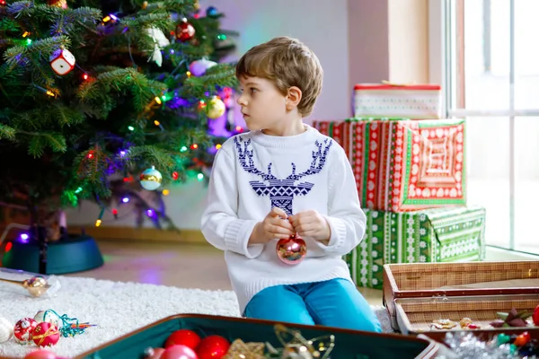 Vacker pojke och färgglada vintage xmas leksaker och bollar. Barn dekorera julgran — Stockfoto