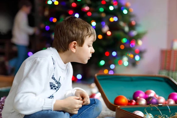 Vacker pojke och färgglada vintage xmas leksaker och boll i gamla resväska. — Stockfoto