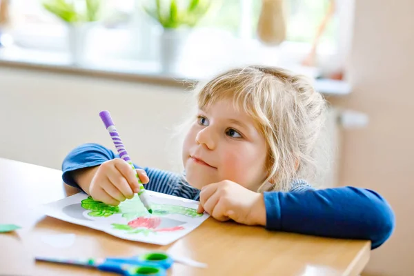 Μικρό κοριτσάκι ζωγραφίζει ζώα και χρησιμοποιεί ψαλίδι. Έννοια της δράσης των παιδιών κατά τη διάρκεια της καραντίνας του ιού της πανδημίας. Παιδιά μαθαίνουν χρώματα με τους γονείς στο σπίτι — Φωτογραφία Αρχείου