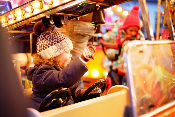 Sevimli küçük çocuk kız üstünde neşeli gitmek yuvarlak atlıkarınca at Noel lunapark veya market, açık havada, At Binme. Dresden, Almanya geleneksel aile xmas piyasada eğleniyor mutlu çocuk