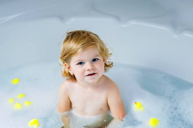 Çok sevimli şirin küçük yürümeye başlayan çocuk kız alma banyo küvet içinde. Kauçuk sakız oyuncaklar ile oynama ve eğlenerek mutlu sağlıklı bebek çocuk. Yıkama, temizlik, hijyen çocuklar için