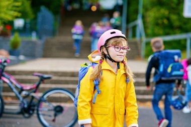 Küçük kız okula yürüyor. Okul bahçesinde çantalı ve gözlüklü şirin bir çocuk. Okula dönelim. Mutlu okul zamanları.