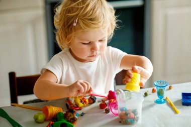 Evinde renkli kille sevimli, küçük bir kız. Sağlıklı bir bebek çocuk yuvasında ya da oyun okulunda hamur oynarken oyuncak yaratıyor. Kil kalıbı çıkaran küçük bir çocuk, yaratıcı aktivite.
