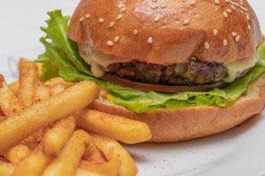 Etli hamburger, domates, marul ve patates kızartması..