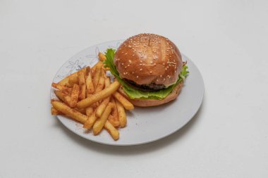 Etli hamburger, domates, marul ve patates kızartması..