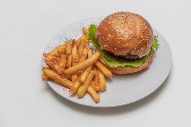 Etli hamburger, domates, marul ve patates kızartması..
