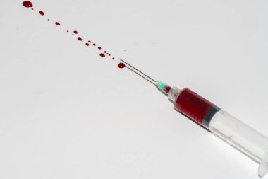 Beyaz arka planda kan olan şırınga