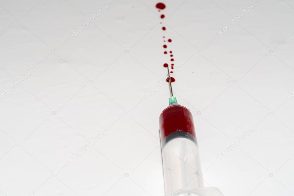 Syringe with blood on white background