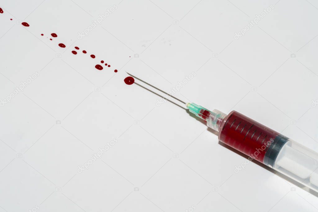 Syringe with blood on white background