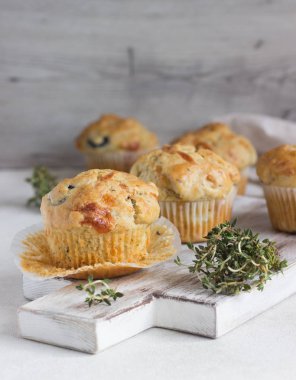 Açık gri arka planda tavuk, peynir ve zeytinli kek. Tuzlu kekler. Sağlıklı öğle yemeği veya atıştırmalık.