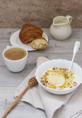 Sağlıklı kahvaltı kase: armut, bal ve granola ahşap zemin üzerine yoğurtlu