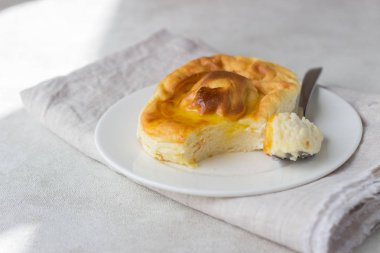 Beyaz tabakta bal süzme peynir güveç. Puding süzme peynir pişmiş.