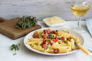 Sosis, dolmalık biber, peynir ve kekik Beyaz ahşap zemin üzerinde plaka ile penne makarna. 