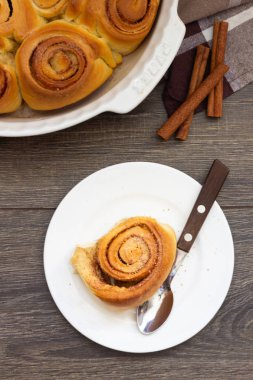 Tarçınlı çörek beyaz tabakta ve beyaz seramik form ve tarçın