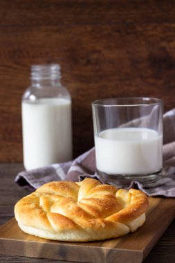 Ahşap masa üzerinde süt şişesiyle taze lezzetli ekmek.